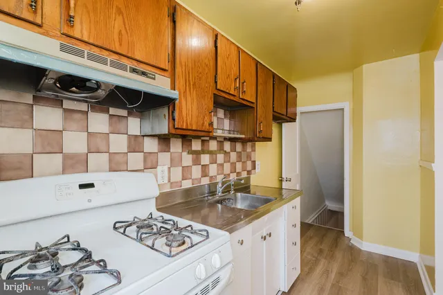 a kitchen with a sink a stove and a refrigerator