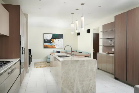 a large white kitchen with a stove a sink a refrigerator and a cabinets