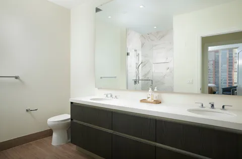 a bathroom with a sink a toilet and a mirror