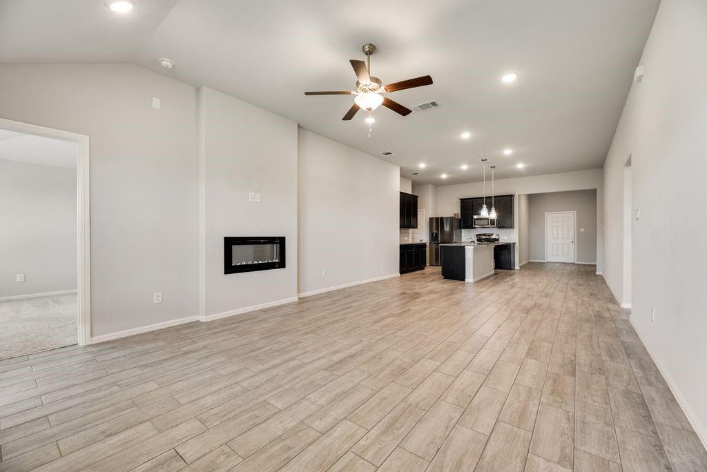 14216 Aberavon Drive Pilot Point, TX 76258 - Photo 10 of 19 Spacious living area featuring wood-look tile flooring, vaulted ceilings, and recessed lighting
