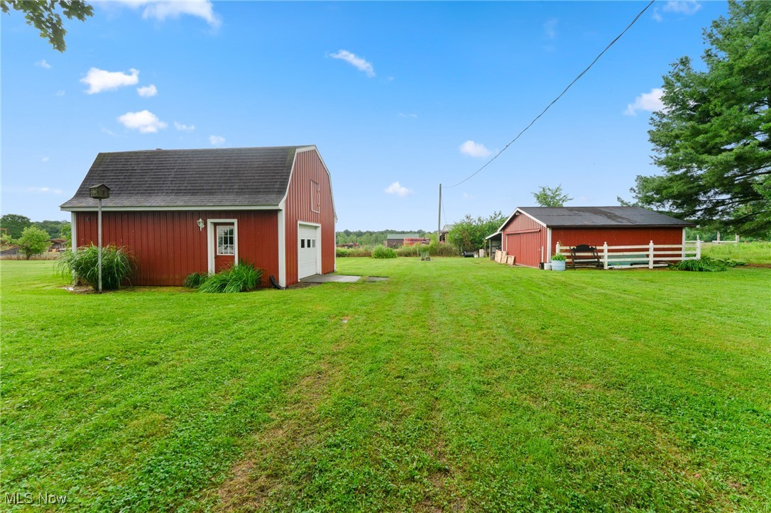 744 Johnson Plank Road Warren, OH 44481 - Photo 28 of 39 View of grassy yard featuring a 2-story barn and outbuilding.