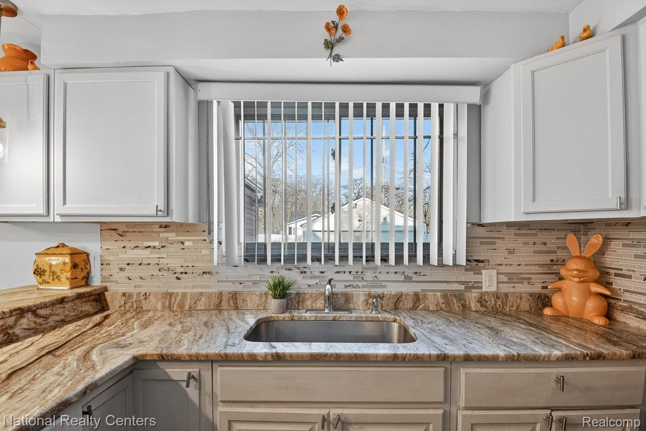 3956 Harvard Road Detroit, MI 48224 - Photo 18 of 44 Kitchen featuring light stone counters and white cabinets
