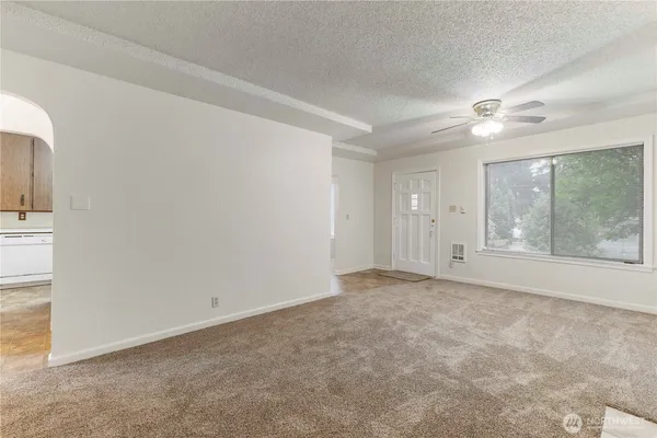 a view of an empty room with a ceiling fan