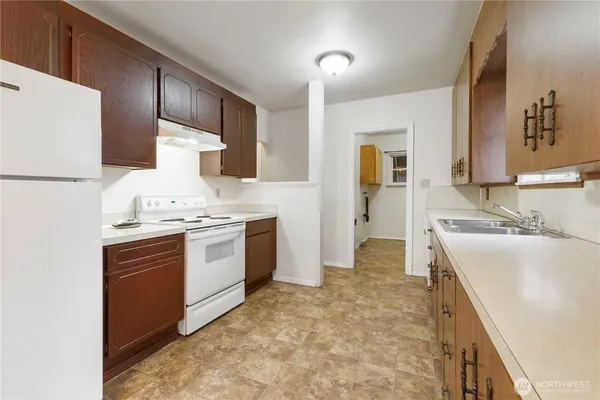 a large kitchen with a sink and refrigerator