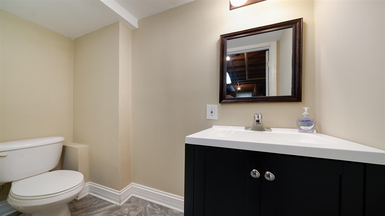 310 Pembroke Road Southwest Poplar Grove, IL 61065 - Photo 14 of 27 a bathroom with a toilet sink vanity and mirror