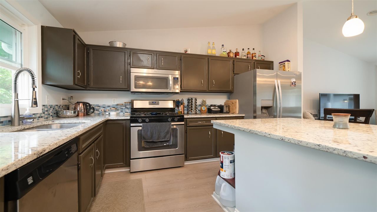 310 Pembroke Road Southwest Poplar Grove, IL 61065 - Photo 3 of 27 a kitchen with kitchen island granite countertop a sink a stove top oven a refrigerator cabinets and a counter top space