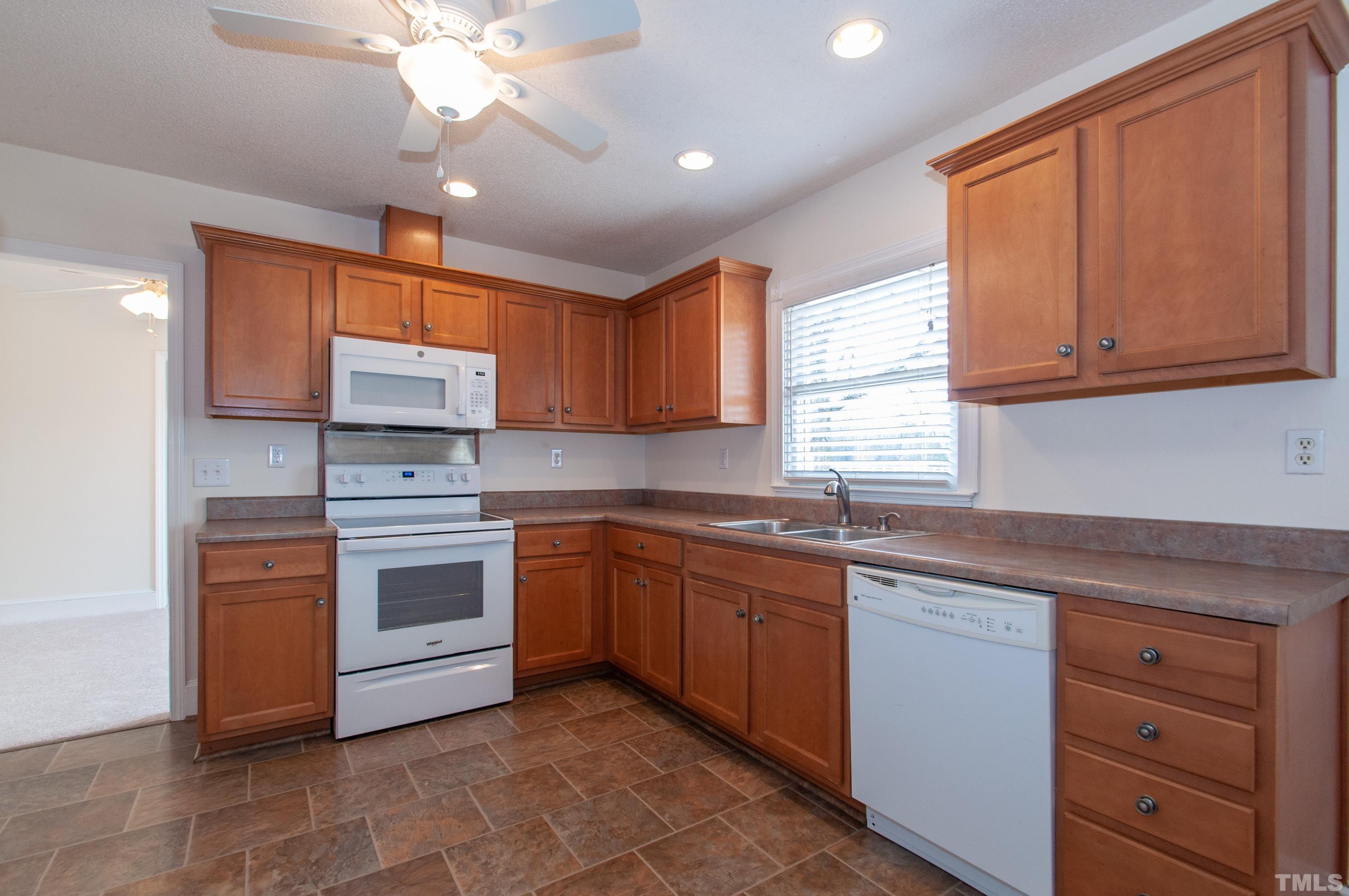 6756 Rock Quarry Road Garner, NC 27529 - Photo 8 of 33 a kitchen with stainless steel appliances granite countertop a sink dishwasher stove and cabinets