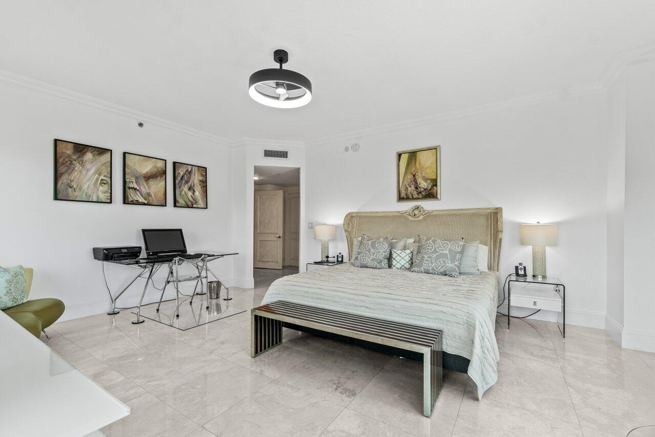 3740 South Ocean Boulevard, Unit 201 Highland Beach, FL 33487 - Photo 19 of 62 a bedroom with a bed and a chandelier