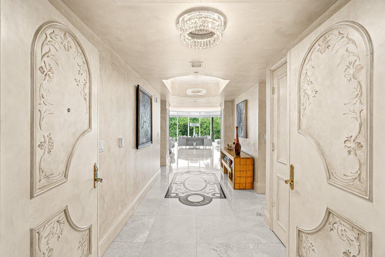 3740 South Ocean Boulevard, Unit 201 Highland Beach, FL 33487 - Photo 2 of 62 a view of entrance with wooden floor and a chandelier