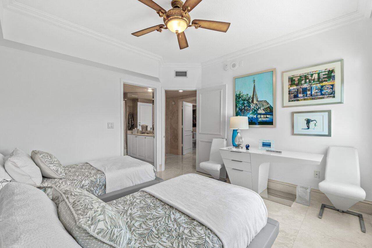 3740 South Ocean Boulevard, Unit 201 Highland Beach, FL 33487 - Photo 31 of 62 a bedroom with a bed a couch and a chandelier