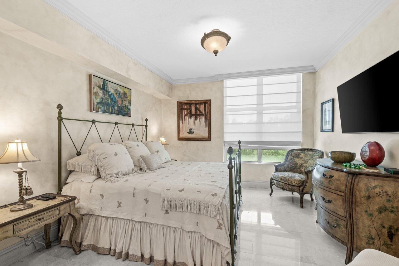 3740 South Ocean Boulevard, Unit 201 Highland Beach, FL 33487 - Photo 33 of 62 a bedroom with a bed and flat screen tv