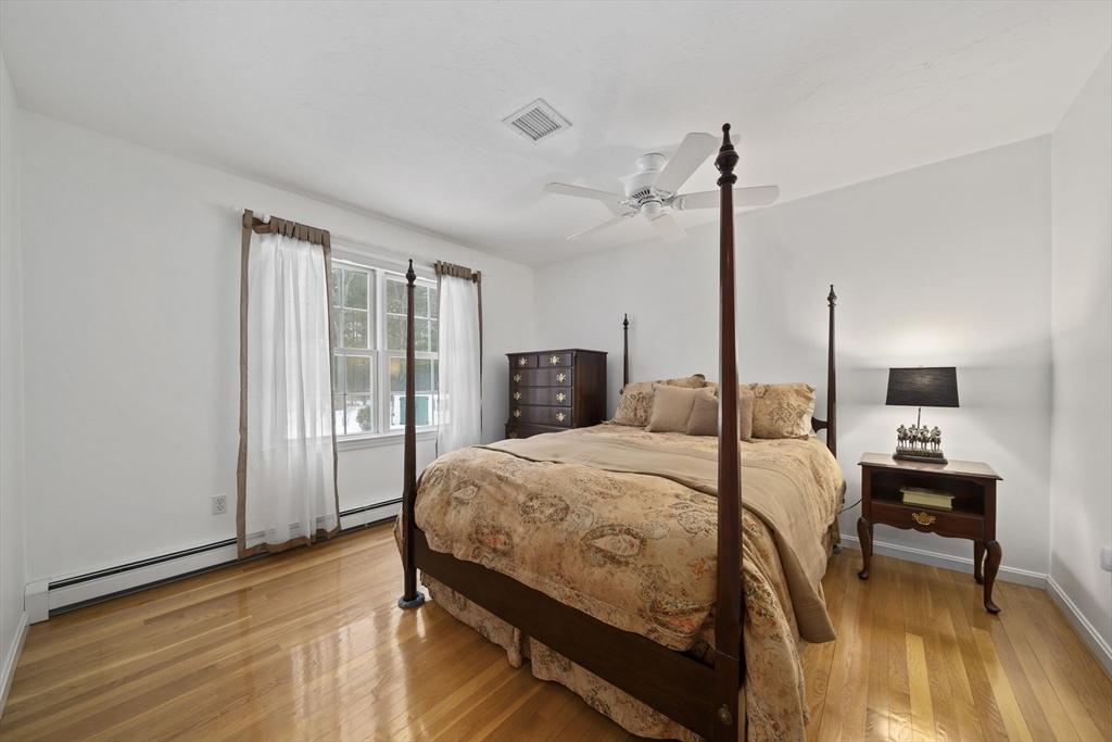 86 Telegraph Hill Road Marshfield, MA 02050 - Photo 22 of 42 a bedroom with a bed a table and wooden floor