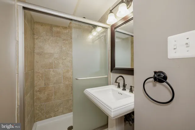 a bathroom with a sink mirror and a shower