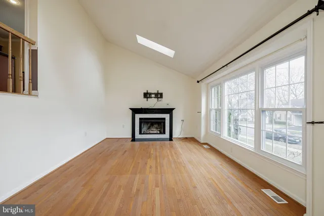 a view of empty room with wooden floor and fireplace