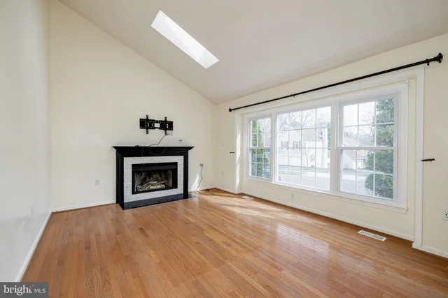 a view of an empty room with a window and fireplace