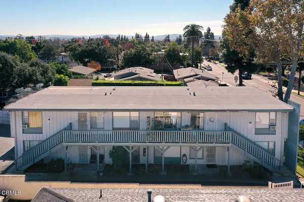 a view of a white house with a yard and sitting area