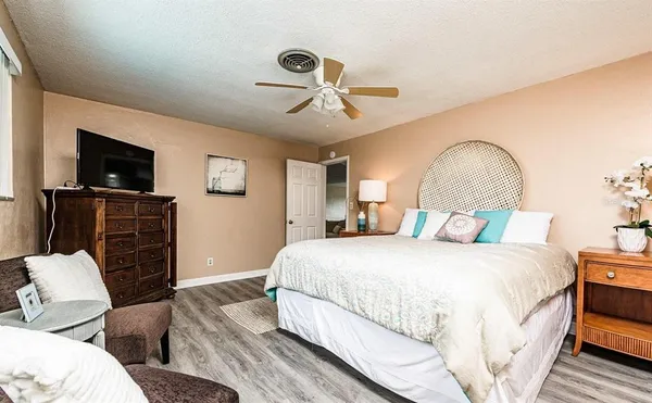 a spacious bedroom with a bed and a flat screen tv