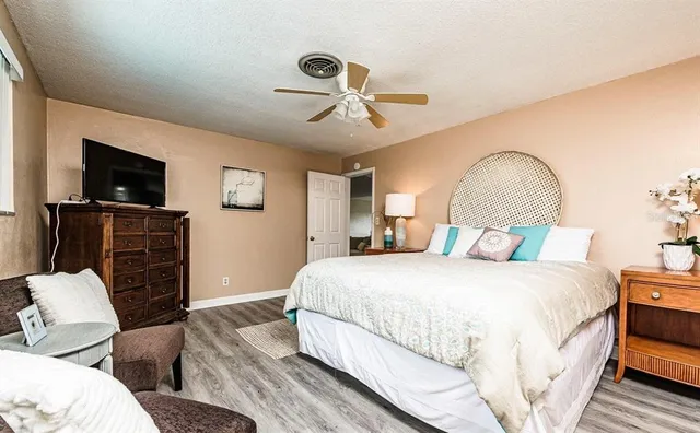 a spacious bedroom with a bed and a flat screen tv