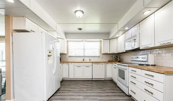 a kitchen with white cabinets and white appliances