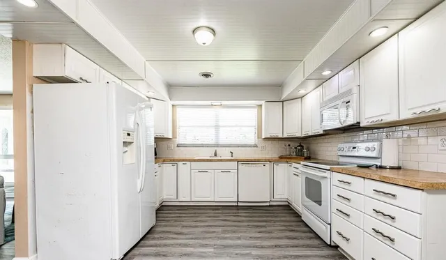 a kitchen with white cabinets and white appliances