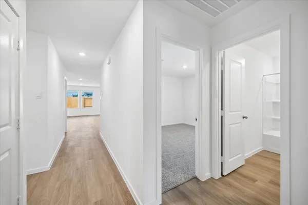 a view of a hallway with wooden floor and staircase