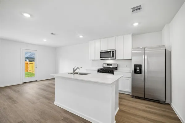 a kitchen with stainless steel appliances a refrigerator sink and microwave
