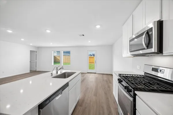 a kitchen with stainless steel appliances a sink stove and microwave