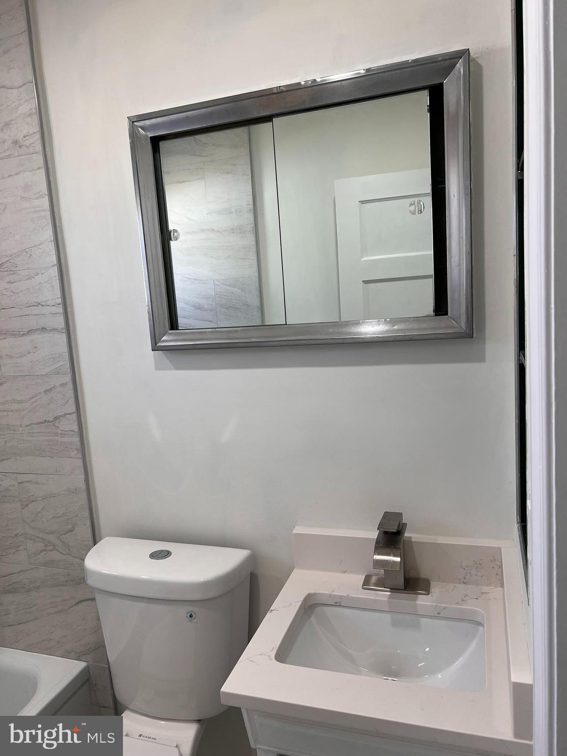 1325 Fuselage Avenue Baltimore, MD 21220 - Photo 8 of 10 a bathroom with a toilet sink and mirror