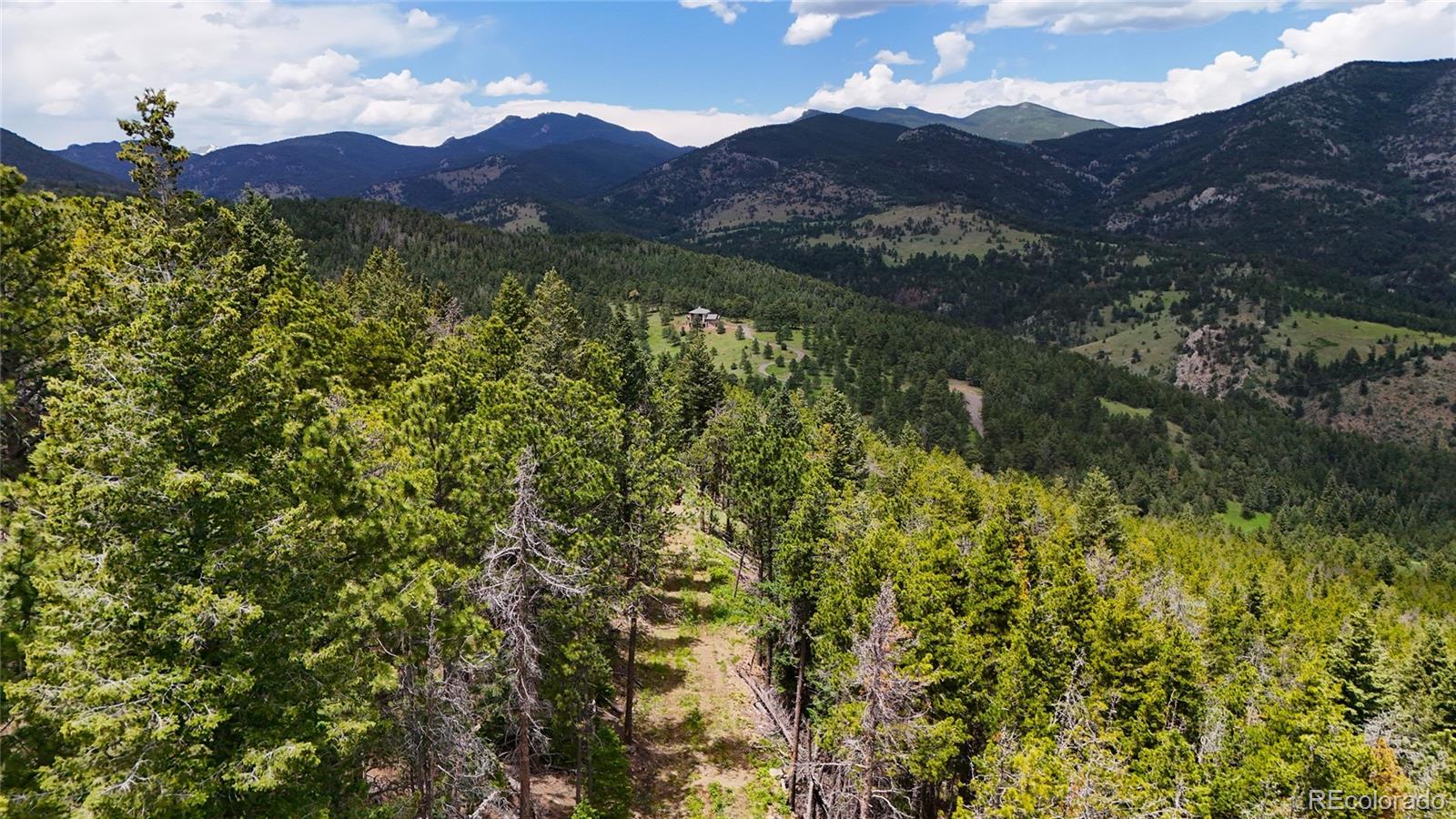 8077 Drew Hill Road Golden, CO 80403 - Photo 18 of 50 a view of a lush green hillside and a building