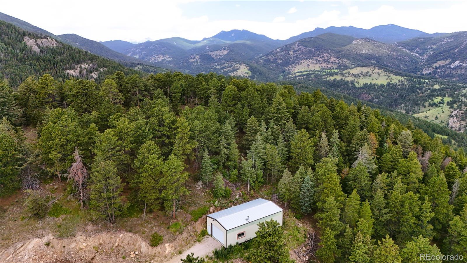 8077 Drew Hill Road Golden, CO 80403 - Photo 30 of 50 a view of a lush green hillside and a houses