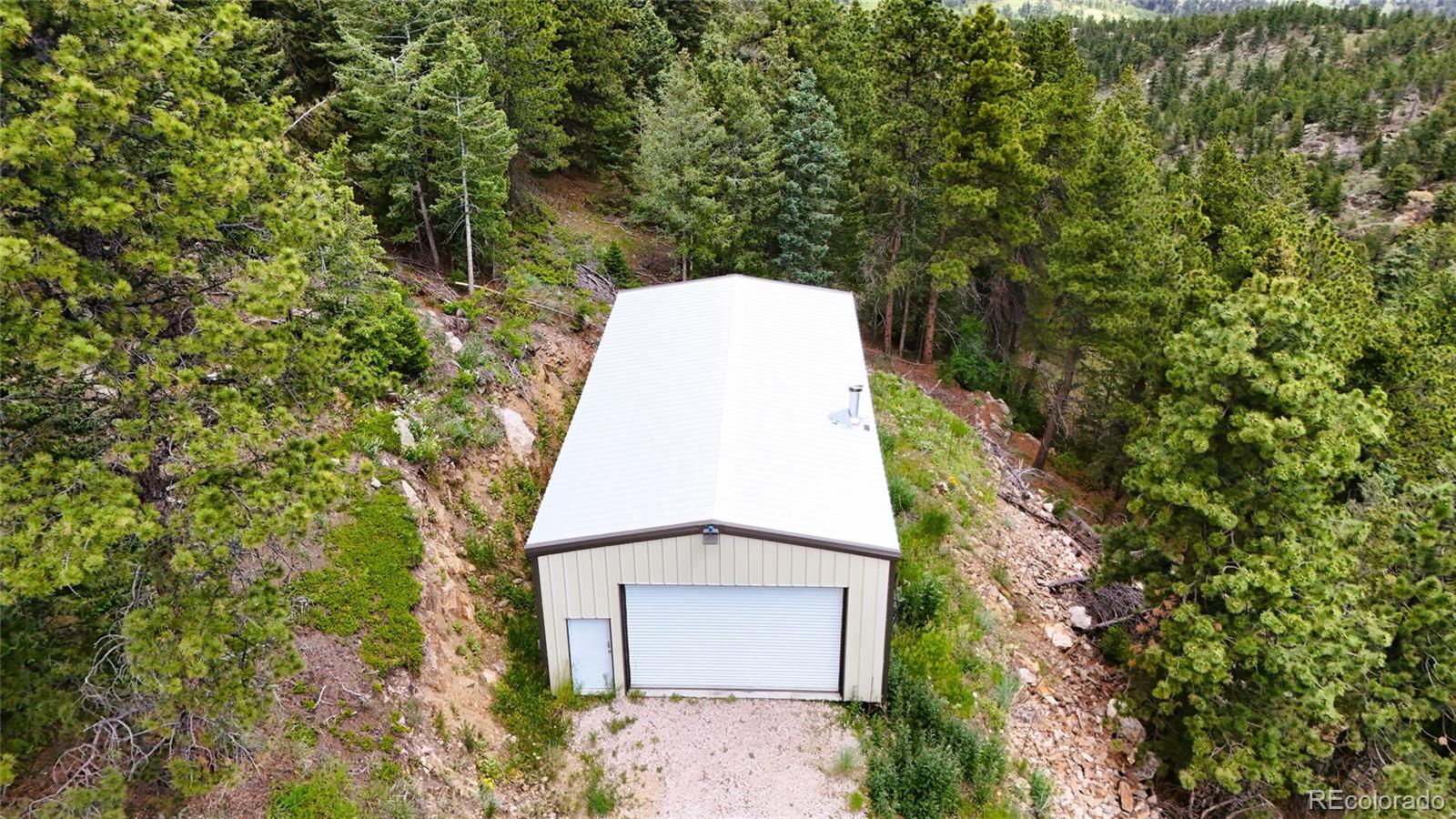 8077 Drew Hill Road Golden, CO 80403 - Photo 32 of 50 a aerial view of a house with a yard and large trees
