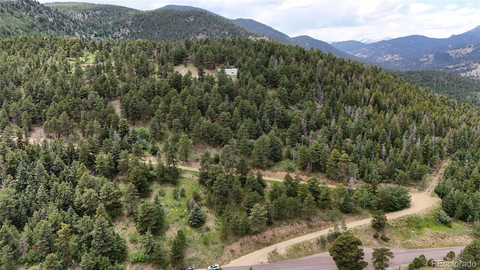 8077 Drew Hill Road Golden, CO 80403 - Photo 38 of 50 a view of a lush green hillside and a houses