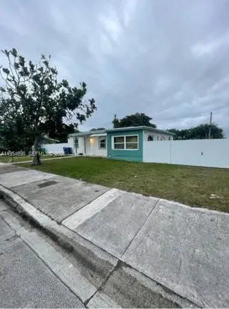 a view of a house with a yard and a large parking space