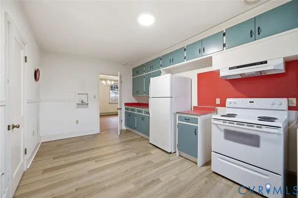 a kitchen with a stove top oven and refrigerator
