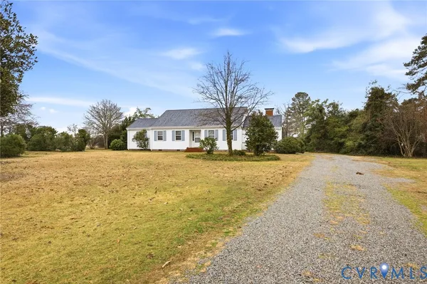 a view of house with outdoor space and trees in the background
