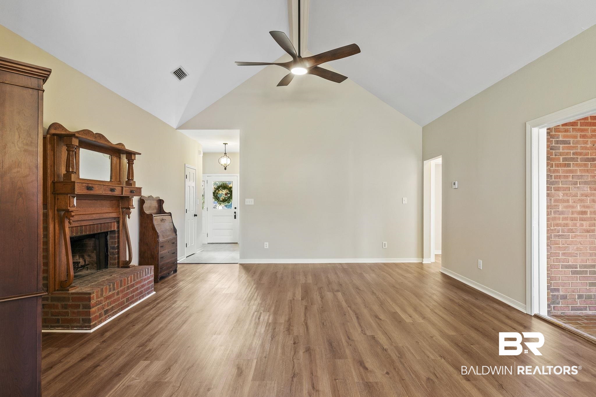9631 Bay Meadows Avenue Fairhope, AL 36532 - Photo 12 of 49 Unfurnished living room with hardwood / wood-style floors, ceiling fan, a fireplace, and high vaulted ceiling