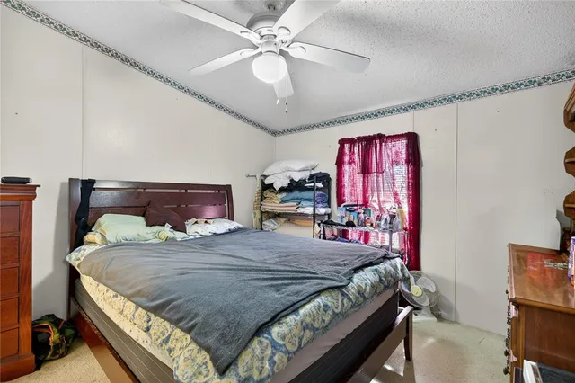 a bedroom with a bed a chandelier and dresser