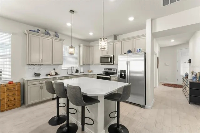 a kitchen with refrigerator cabinets and chairs