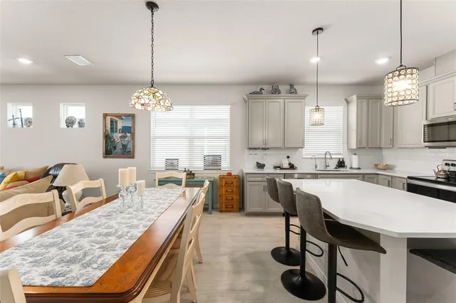 a large kitchen with kitchen island a dining table chairs and a wooden floor