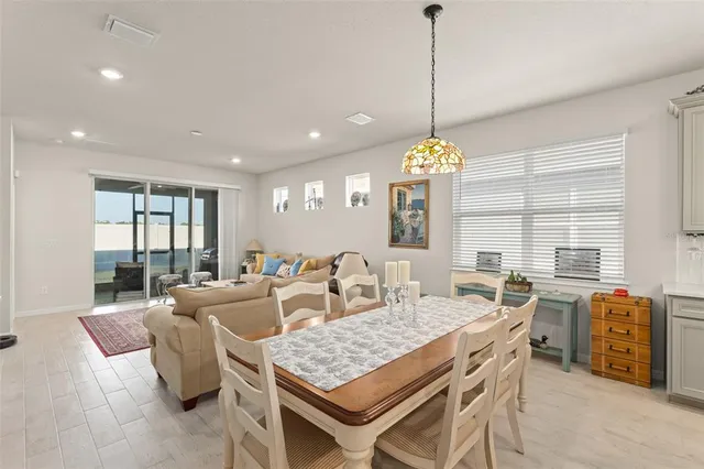 a dining table chairs and a chandelier