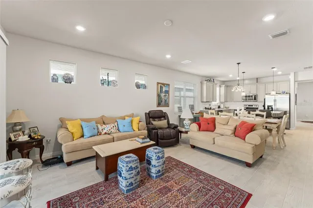 a living room with furniture and view of kitchen
