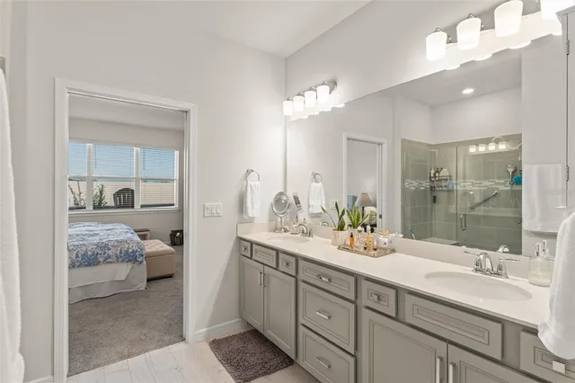 a en suite bathroom with double sink a mirror and shower