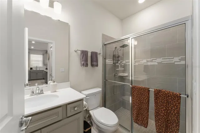 a bathroom with a sink toilet vanity and shower