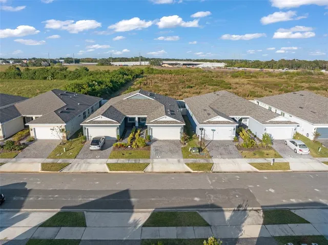 an aerial view of residential houses with outdoor space and ocean view