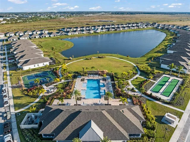 an aerial view of ocean and residential houses with outdoor space