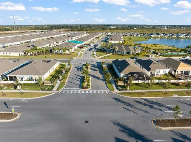 an aerial view of residential houses with outdoor space and ocean view