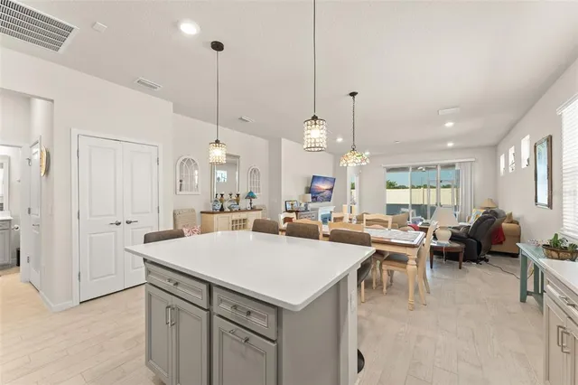 a large kitchen with kitchen island a stove a sink a center island a dining table and chairs