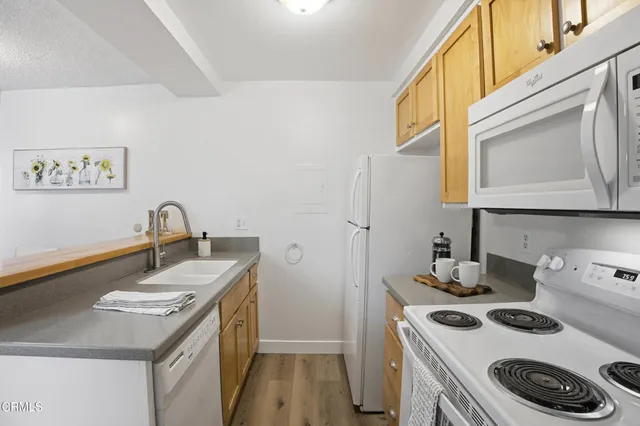a kitchen with a sink a stove and cabinets