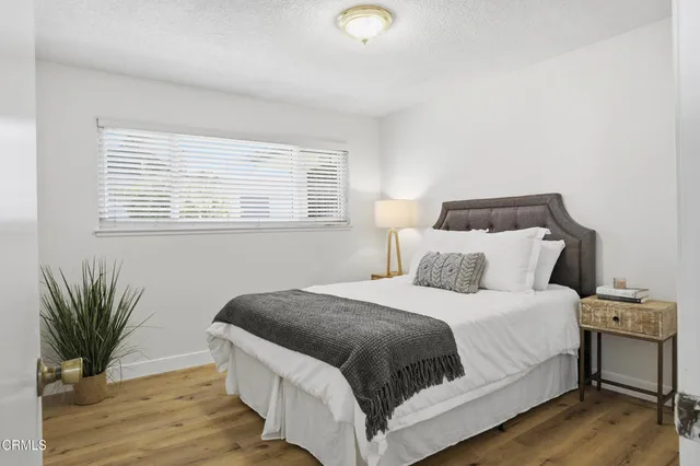 a bedroom with a bed and a potted plant