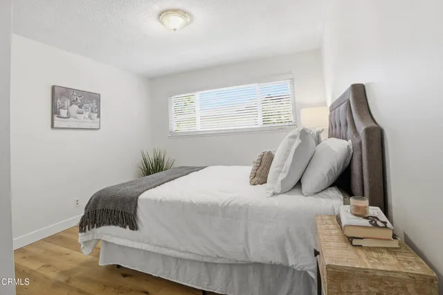 a bedroom with a bed and painting on the wall